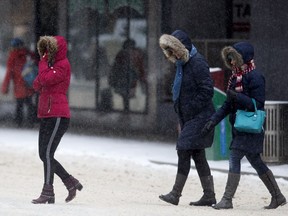 Pedestrians make their way through the cold and snow near 101 Street and Jasper Avenue, in Edmonton Friday Feb. 1, 2019.