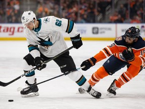 Edmonton Oilers' Jujhar Khaira (16) reaches for San Jose Sharks' Kevin Labanc (62) during the second period of a NHL game at Rogers Place in Edmonton, on Saturday, Feb. 9, 2019.