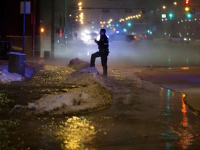 A police officer works at the scene of a huge water line break near 104 Avenue and 109 Street on Friday, Feb. 15, 2019.
