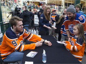 Mason FranKo and daughter Alivia, 6, get an autograph from Edmonton Oiler Connor McDavid at West Edmonton Mall on Monday, Feb. 18, 2019, in Edmonton.