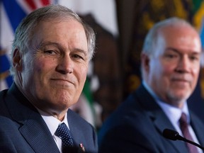 Washington State Gov. Jay Inslee, left, and British Columbia Premier John Horgan listen during a news conference in Vancouver, B.C., on Friday March 16, 2018.