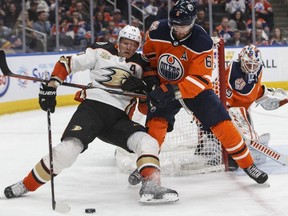 Anaheim Ducks forward Corey Perry (10) and Edmonton Oilers defenceman Adam Larsson (6) battle for the puck during third period NHL action at Rogers Place on Saturday February 23, 2019.