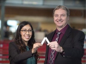 University of Alberta Mitacs fellow Christina Gonzalez and Applied Quantum Materials Inc. CEO David Antoniuk hold up a small strip of paper they have designed to detect explosives. (Supplied)