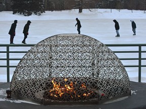 The fires burning as people skate on the blustery afternoon on the frozen pond at Hawrelak Park in Edmonton, February 20, 2019.