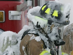 A firefighter is seen covered in ice after battling a house fire in cold weather in this file photo.