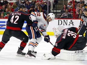 Edmonton Oilers' Tobias Rieder (22) has his shot frozen by Carolina Hurricanes goaltender Curtis McElhinney (35) with Greg McKegg (42) nearby during the first period of an NHL hockey game, Friday, Feb. 15, 2019, in Raleigh, N.C.