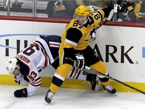 Pittsburgh Penguins' Sidney Crosby (87) collides with Edmonton Oilers' Ryan Nugent-Hopkins (93) during the first period of an NHL hockey game in Pittsburgh, Wednesday, Feb. 13, 2019.