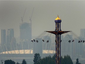 Downtown Vancouver seen in the haze behind The Atmosfear ride at the PNE in Vancouver, Aug. 13, 2018.