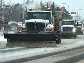 Three city snow plows head down 97 Avenue during a snowstorm in February 2019.