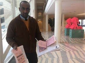 Nyala Lounge owner Mulugeta Tesfay holds stacks of bylaw tickets issued against him by the city. Tesfay has successfully fought many of the tickets, but he is also fighting to keep his business licence, and attended an appeal hearing at city hall on Friday, Feb. 8, 2019.