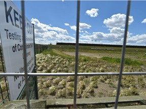 Fencing has been installed as other workers drill core samples (R) in a contaminated parcel at the old wood treatment plant site, Domtar, where a section of unoccupied land nearby was contaminated enough that a metal fencing was erected near 43 St. and Yellowhead Tr. in Edmonton, June 28, 2018.