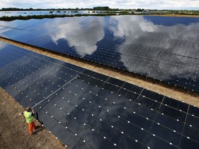 A workman cleans panels at Landmead solar farm near Abingdon, England. Rocky View County has passed land use changes allowing RealPart Canada to move ahead with plans to construct a 954-acre solar farm just outside southeast Calgary.