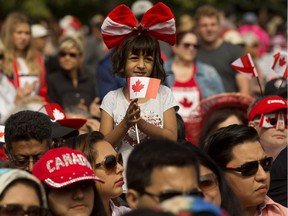 A young girl watches the Canada Day citizenship ceremony at the Alberta Legislature, in Edmonton Sunday July 1, 2018.