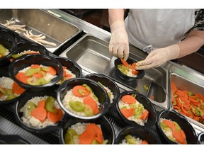 Meals on Wheels volunteer Lynn Donaghey prepares meals for delivery in the kitchen in Edmonton, on Wednesday, March 6, 2019.