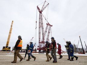 Crews walk past the polypropylene reactor and the giant crane being used to raise it into position at the Heartland Petrochemical Complex in Fort Saskatchewan on Thursday, March 7, 2019, where the federal government announced an investment in Alberta petrochemical innovation during a news conference at the complex.