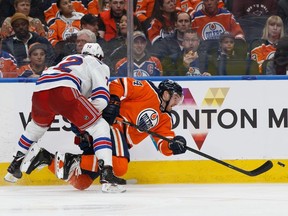 Edmonton Oilers' Brad Malone (24) battles New York Rangers' Filip Chytil (72) during the second period of a NHL game at Rogers Place in Edmonton, on Monday, March 11, 2019.