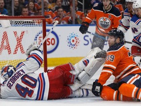 Edmonton Oilers' Alex Chiasson (39) is nearly kicked in the face as he battles New York Rangers' goaltender Alexandar Georgiev (40) during the third period of a NHL game at Rogers Place in Edmonton, on Monday, March 11, 2019.
