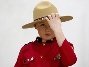Sayber Skeels, 9, adjusts her uniform as she takes part in Alberta RCMP's "dream experience" with the Kids with Cancer Society at RCMP K Division headquarters, in Edmonton on Tuesday, March 12, 2019. Skeels and four kids from the Kids with Cancer Society, along with their families, took part in the event, meeting police service dog Hulk, checking out police vehicles, and even taking a ride in a RCMP helicopter.