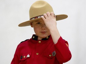 Sayber Skeels, 9, adjusts her uniform as she takes part in Alberta RCMP's "dream experience" with the Kids with Cancer Society at RCMP K Division headquarters, in Edmonton on Tuesday, March 12, 2019. Skeels and four kids from the Kids with Cancer Society, along with their families, took part in the event, meeting police service dog Hulk, checking out police vehicles, and even going on a helicopter ride.