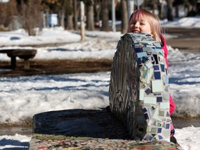 Charley Charest, 6, plays around a community built art bench outside of Holyrood School in Edmonton, on Friday, March 15, 2019. The bench helps improve walkability in the area and was built after a boy was struck and killed by a truck while walking to school.