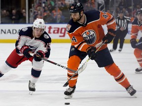 Edmonton Oilers forward Zack Kassian, right, battles the Columbus Blue Jackets' Ryan Dzingel during first period NHL action at Rogers Place in Edmonton on March 21, 2019.