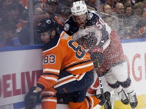 The Edmonton Oilers defenceman Matt Benning battles the Columbus Blue Jackets' Eric Robinson (50) during second period NHL action at Rogers Place, in Edmonton Thursday March 21, 2019.