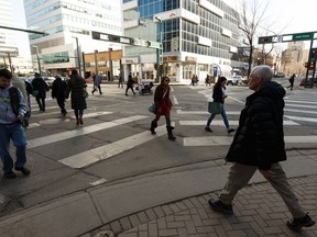 Pedestrians walk across the scramble intersection at Jasper Avenue and 104 Street in Edmonton, on Friday, March 29, 2019. Edmonton's city census launches April 1.