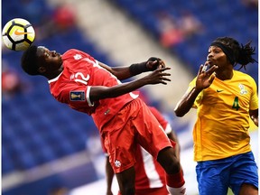 French Guiana's forward Rhudy Evens (R) and Canada's midfielder Alphonso Davies vie for the ball during their 2017 Concacaf Gold Cup Group A match at the Red Bull Arena in Harrison, New Jersey, on July 7, 2017.