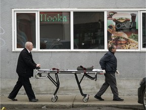 Staff from the medical examiner's office arrive to remove a body from the Xhale Lounge, a hookah bar located at 8120 101 Street, on Sunday March 24, 2019. The victim died of a gunshot wound and was confirmed as the ninth homicide of 2019.