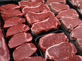 Steaks and other beef products are displayed for sale at a grocery store.