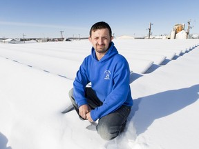 Mike Bryant, Aquatic Maintenance with the Town of Barrhead, with snow covered solar panels on the town's aquatic centre that was paid for with money collected from the carbon tax.