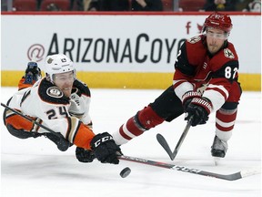 Anaheim Ducks center Carter Rowney (24) shoots in front of Arizona Coyotes defenseman Jordan Oesterle during the third period during an NHL hockey game Thursday, March 14, 2019, in Glendale, Ariz. Arizona defeated Anaheim 6-1.