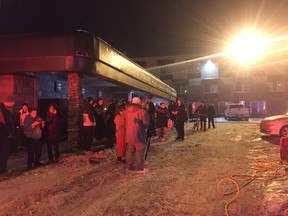 Residents from Dwayne's Home watch as Edmonton firefighters work to battle an early morning fire at the downtown Edmonton residence on Tuesday March 12, 2019.