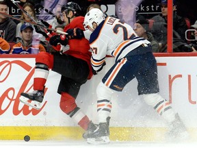 Edmonton Oilers' Milan Lucic (27) collides with Ottawa Senators' Dylan DeMelo during first period NHL action in Ottawa, Thursday, Feb. 28, 2019.