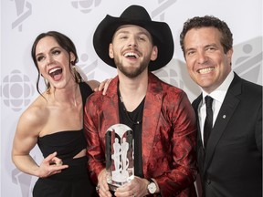 Canadian figure skater Tessa Virtue, left, poses with Brett Kissel, winner of the Juno for best country album of the year, and Rick Mercer backstage at the Juno Awards in London, Ont., on March 17, 2019.