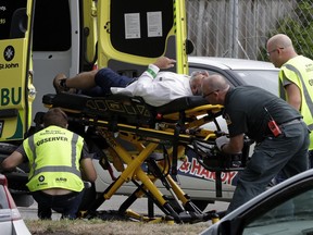 Ambulance staff take a man from outside a mosque in central Christchurch, New Zealand, Friday, March 15, 2019.  A witness says many people have been killed in a mass shooting at a mosque in the New Zealand city of Christchurch.