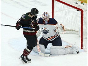 Arizona Coyotes right wing Conor Garland, left, sets a screen as Edmonton Oilers goaltender Mikko Koskinen, right, gives up a goal to Coyotes' Alex Galchenyuk during the first period of an NHL hockey game Saturday, March 16, 2019, in Glendale, Ariz.