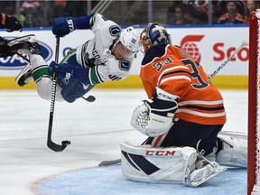 Vancouver Canucks Markus Granlund (60) gets tripped in front of Edmonton Oilers goalie Cam Talbot (33) during NHL pre-season action at Rogers Place in Edmonton on Sept. 25, 2018.