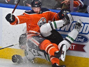 Edmonton Oilers Oscar Klefbom (77) hits Dallas Stars Ben Lovejoy (21) along the boards during NHL action at Rogers Place in Edmonton, March 28, 2019. Ed Kaiser/Postmedia