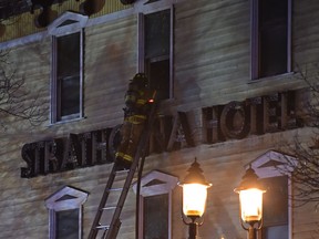 Firefighters and aerial trucks fight a fire in the Strathcona Hotel, which is under renovation, on Edmonton's Whyte Avenue on March 29, 2019.