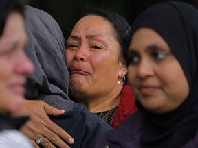 A mourner reacts after paying her respects in near the Masjid Al Noor mosque in Christchurch, New Zealand, Monday, March 18, 2019. A steady stream of mourners paid tribute at makeshift memorial to the 50 people slain by a gunman at two mosques in Christchurch, while dozens of Muslims stood by to bury the dead when authorities finally release the victims' bodies.