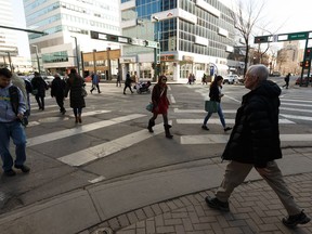 Pedestrians walk across the scramble intersection at Jasper Avenue and 104 Street in Edmonton, on Friday, March 29, 2019.