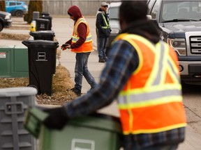 Workers deliver new waste carts in the Ellerslie neighbourhood as part of a waste pilot project in Edmonton, on Monday, April 1, 2019. About 8,000 homes in 13 neighbourhoods were selected to participate in the waste separation pilot.