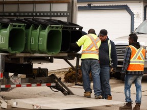 Workers deliver new organic green bins in the Ellerslie neighbourhood as part of the waste cart pilot project. (Postmedia, File)