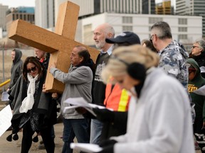 Oscar Vargas helps carry the cross during the 39th Annual Good Friday Outdoor Way of the Cross in Edmonton, on Friday, April 19, 2019. The march addresses social concerns, airs a vision of hope and challenges to participants to work towards social change.