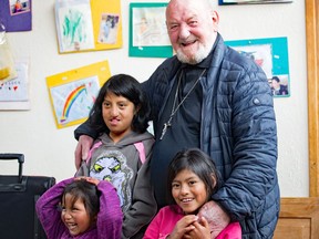 Padre Pio, who has worked for 44 years as a missionary in Ecuador, with two orphans at the Zumbahua orphanage four hours from Quito and some 14,000 ft. up in the Ecuadorean foothills. Padre Pio invited members of Edmonton's Canadian Volunteers for International Development Society to Ecuador and let medical staff use his hospital in Cayambe.