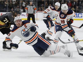 Edmonton Oilers center Connor McDavid falls beside right wing Alex Chiasson during the third period of an NHL hockey game against the Vegas Golden Knights, Monday, April 1, 2019, in Las Vegas.