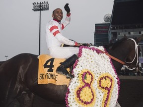 Rico Walcott celebrates atop Sky Promise after they won the Canadian Derby in Edmonton August 25, 2018.