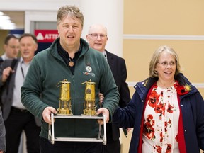 Christopher Shaw, Chairman of the Shorncliffe-Trust and Terry Plant, Canadian Educational Tour Planning representative, carry the Eternal Flames dubbed Tommy (for our English friends) and Maple (for our Canadians) into the airport on Monday, April 15, 2019, in Edmonton . The Eternal Flame made its way from Belgium through France (stopping at Vimy Ridge and Beaumount-Hamel) to England (to Shorncliffe Camp where the soldiers trained and where 309 Canadians are buried) and then to Edmonton. The Flame will eventually reside at the Edmonton Garrison Memorial Golf & Curling Club where families can visit and take their copy of the Flame to their communities and homes.