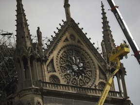 Technicians work in a crane next to the Notre Dame cathedral in Paris, Monday, April 22, 2019. n the wake of the fire last week that gutted Notre Dame, questions are being raised about the state of thousands of other cathedrals, palaces and village spires that have turned France -- as well as Italy, Britain and Spain -- into open air museums of Western civilization.